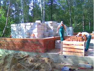 Фундамент коттеджа готов, для кладки стен заготовлен кирпич и другие строительные материалы